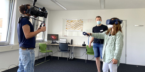 Das Foto zeigt Kameramann Max Gies und Reporterin Aleyna-Sofie Dülger, die gemeinsam mit Philip Zweihoff die VR-Brille des DataSpace testen.