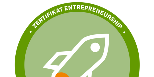 Logo des Zertifikats Entrepreneurship. Ein hellgrüner Kreis mit einer weißen einfach dargestellten Rakete mit orangener Flamme, die schräg nach oben fliegt. Außen ein dunkelgrüner Ring mit der Aufschrift "Zertifikat Entrepreneurship"