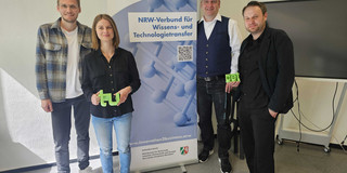 4 Personen vor einem Banner