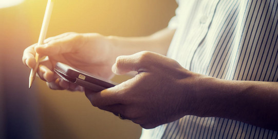 Eine Person hält ein Tablet und einen Stift in den Händen